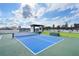 Bright blue tennis court and lush rooftop terrace with well-manicured lawn, outdoor dining, and scenic city views at 2425 Peachtree Rd # 1806, Atlanta, GA 30305