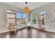 Sunlit breakfast nook with hardwood floors, neutral walls, large windows, and wicker-style furniture at 414 Montclair Ct, Woodstock, GA 30188