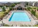 A wide view of a community swimming pool with lounge chairs, green lawn, and the pool house at 414 Montclair Ct, Woodstock, GA 30188