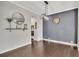 Dining room with hardwood floors, gray accent wall and modern lighting fixture at 414 Montclair Ct, Woodstock, GA 30188