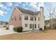 Back exterior featuring a two-story home with brick and siding, a spacious backyard, and attached garage at 190 Holcomb Ct, Fayetteville, GA 30215