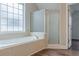 A tile-trimmed bathtub sits adjacent to a glass enclosed shower at 190 Holcomb Ct, Fayetteville, GA 30215