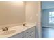 Bathroom with double sinks, white cabinets, and neutral walls at 190 Holcomb Ct, Fayetteville, GA 30215