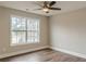 Bright bedroom featuring a large window, ceiling fan, and hardwood floors at 190 Holcomb Ct, Fayetteville, GA 30215