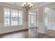 The dining room has hardwood floors, a modern light fixture, and a large window overlooking the front yard at 190 Holcomb Ct, Fayetteville, GA 30215