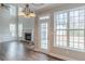 Bright living room featuring a fireplace, large windows, wood floors, and a door leading to the backyard at 190 Holcomb Ct, Fayetteville, GA 30215