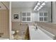 Bathroom featuring tan tile, a white vanity with a sink, and a window with shutters at 2111 Jade Dr, Canton, GA 30115