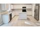 Bright kitchen with white cabinetry, an island, stainless steel appliances, and tile floors at 3160 Sable Trl, Atlanta, GA 30349