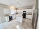 Spacious kitchen featuring white cabinets, an island, stainless steel appliances, and tile flooring at 3160 Sable Trl, Atlanta, GA 30349