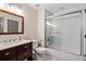 Modern bathroom featuring a marble countertop, tile shower with glass door, and updated fixtures at 10635 N Edgewater Pl, Johns Creek, GA 30097
