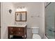 Bathroom with modern dark wood vanity, framed mirror, and tiled shower with glass door at 10635 N Edgewater Pl, Johns Creek, GA 30097