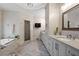 Luxurious bathroom with soaking tub, walk-in shower, and beautiful herringbone tile flooring at 10635 N Edgewater Pl, Johns Creek, GA 30097