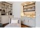 Butler's pantry with marble counters, backsplash, and open shelving at 10635 N Edgewater Pl, Johns Creek, GA 30097