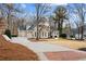 View of the brick home's driveway leading to a two-car garage with a beautiful blue sky at 10635 N Edgewater Pl, Johns Creek, GA 30097