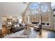 Bright and open living room with a vaulted ceiling and a large arched window overlooking nature at 10635 N Edgewater Pl, Johns Creek, GA 30097