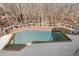 Backyard swimming pool with a deck and diving board surrounded by a serene wooded area for leisure and recreation at 10635 N Edgewater Pl, Johns Creek, GA 30097