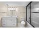Bright bathroom features a white vanity, framed mirror, sleek lighting, and a glass-enclosed shower with white subway tile at 3817 Paces Ferry West, Atlanta, GA 30339