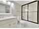 Modern bathroom with shower-tub combo with glass doors and updated vanity at 3817 Paces Ferry West, Atlanta, GA 30339