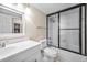 Bright bathroom featuring a shower-tub combo with black frame sliding doors and modern vanity at 3817 Paces Ferry West, Atlanta, GA 30339