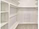 Spacious walk-in closet with white wooden shelving, clothing rods, carpet, and a built in shoe rack at 3817 Paces Ferry West, Atlanta, GA 30339
