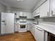 Bright kitchen featuring white appliances, ample cabinet space, and light countertops on wood floors at 3817 Paces Ferry West, Atlanta, GA 30339