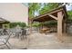 A covered seating area with picnic table and chairs on a patio surrounded by trees at 3817 Paces Ferry West, Atlanta, GA 30339