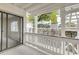 A cozy, covered patio with white railings overlooks a stone wall and lush greenery at 3817 Paces Ferry West, Atlanta, GA 30339