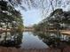 Tranquil view of a pond surrounded by lush trees and greenery, creating a serene natural setting at 3817 Paces Ferry West, Atlanta, GA 30339