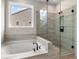 Stylish bathroom featuring a soaking tub and a glass-enclosed shower with modern fixtures at 727 Crossroad Ct, Powder Springs, GA 30127