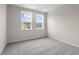 Bright bedroom boasts neutral walls, soft gray carpet, and two sunny windows offering neighborhood views at 727 Crossroad Ct, Powder Springs, GA 30127