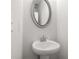 Elegant bathroom with white pedestal sink and modern oval mirror creates a bright space at 1723 Juniper Berry Way, Loganville, GA 30052