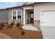 Close up of house with stone accents, two-car garage and a beautiful landscaped yard at 1723 Juniper Berry Way, Loganville, GA 30052