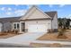 Home with a well-manicured lawn, and a white two-car garage under a blue, cloudy sky at 1723 Juniper Berry Way, Loganville, GA 30052