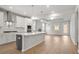 Bright, open-concept kitchen with white cabinets, stainless steel appliances, and large island flows into living area at 1723 Juniper Berry Way, Loganville, GA 30052