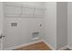 Neutral laundry room including shelving and wood-look flooring at 1723 Juniper Berry Way, Loganville, GA 30052