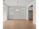 Open-concept dining area with hardwood floors, neutral walls, and modern chandelier at 1723 Juniper Berry Way, Loganville, GA 30052