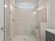 The walk-in shower has white tiling, a glass door, a rain-style shower head, and a shower bench at 1723 Juniper Berry Way, Loganville, GA 30052