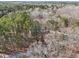 Expansive aerial view of a wooded residential area, showcasing a home nestled among mature trees at 2999 Happy Hollow Dr, Conyers, GA 30094