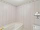 Bathroom featuring vintage wallpaper, a soaking tub, and toilet at 2999 Happy Hollow Dr, Conyers, GA 30094