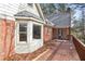Back of house with outdoor deck, bay window, brick facade, and wooded views at 2999 Happy Hollow Dr, Conyers, GA 30094