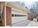 Attached two-car garage featuring brick facade and a well-lit driveway for added convenience and security at 2999 Happy Hollow Dr, Conyers, GA 30094