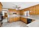 Bright kitchen with wood cabinetry, neutral countertops and black appliances at 2999 Happy Hollow Dr, Conyers, GA 30094