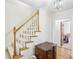 Foyer staircase has carpeted steps with oak handrail and is adjacent to a decorative chest of drawers at 2999 Happy Hollow Dr, Conyers, GA 30094