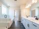 Well-lit bathroom featuring double vanities, frameless glass shower, and modern finishes at 718 Crossroad Ct, Powder Springs, GA 30127