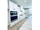 Modern kitchen boasts white cabinetry, stainless steel appliances, and a large island with countertop at 718 Crossroad Ct, Powder Springs, GA 30127