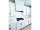 Close-up of white kitchen cabinets, quartz countertops, and stainless steel cooktop and hardware at 718 Crossroad Ct, Powder Springs, GA 30127