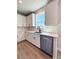 Well-lit kitchen features a stainless steel dishwasher and white cabinets with black hardware at 718 Crossroad Ct, Powder Springs, GA 30127