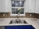 Kitchen area featuring a stainless steel sink, white upper cabinets, and bronze backsplash and flowers at 104 Worthy Drive, Mcdonough, GA 30252