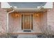 Inviting front entrance with a decorative wooden door, flanked by sconce lighting and brick accents at 1824 Colonial South Sw Dr, Conyers, GA 30094