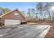 Brick home featuring a large garage, a long driveway, and a beautifully landscaped yard with mature trees at 1824 Colonial South Sw Dr, Conyers, GA 30094